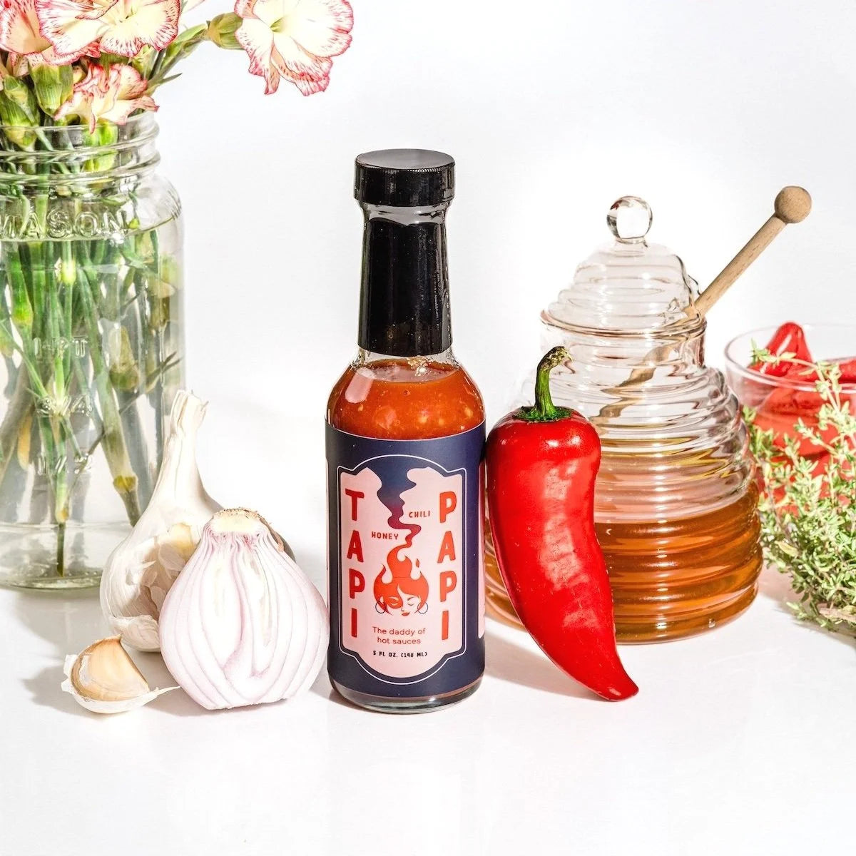 Tapi Papi hot sauce bottle with chili, garlic, honey, and thyme.