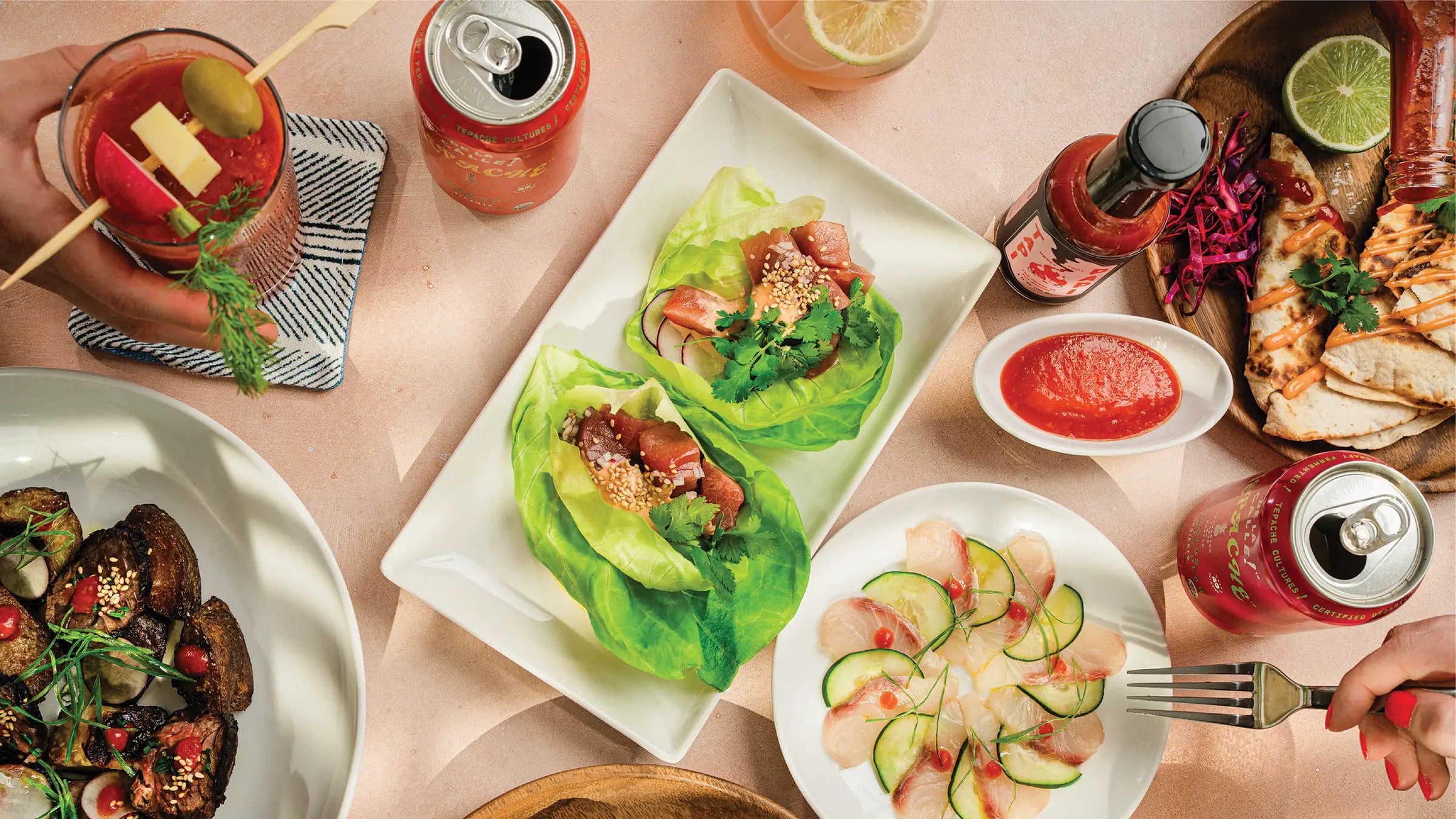 Bloody Mary, fish tacos, ceviche, quesadilla, steak with potatoes, and a bottle of Tapi Papi hot sauce.